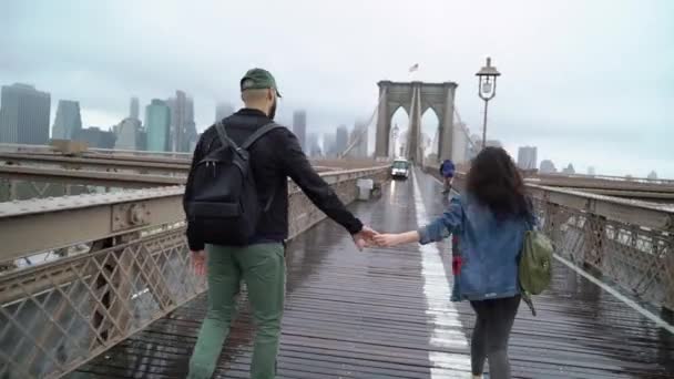 Pasangan muda berjalan di jembatan Brooklyn — Stok Video