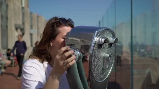 Young woman using scope at observation deck — Stock Video