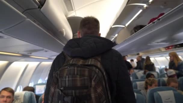 ХЕЛЬСИНКИ, ФИНЛЯНДИЯ - 4 января 2019 года: Молодой человек садится в самолет — стоковое видео