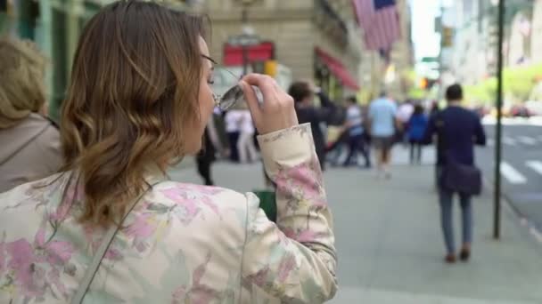 Mujer joven caminando en una ciudad — Vídeos de Stock