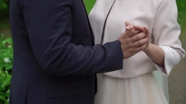 Прекрасная пара невеста и жених держатся за руки — стоковое видео