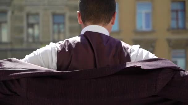 Mann im Anzug trägt Jacke — Stockvideo