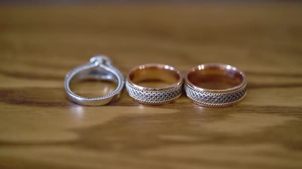 Wedding rings at wooden table — Stock Video