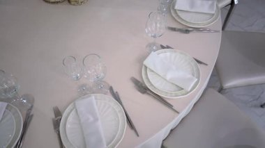 Güzel düzenlenmiş bir yemek masası. Güzel porselenleri ve zarif cam örtüleri var. Özel durumlar için mükemmel.