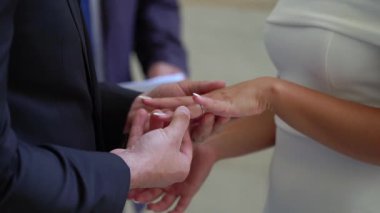 Sonsuz birlikteliklerini sembolize eden samimi bir tören sırasında bir çift yüzüklerini değiş tokuş ediyor.