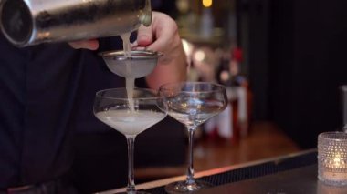 Yetenekli bir barmen zarif, pırıl pırıl bardaklara zarif bir kokteyl koyar.
