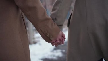 Sevgi dolu bir çift karlı bir arka planda el ele tutuşup kış boyunca derin aşklarını ve bağlantılarını sembolize ederler.