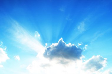 Bulutların önünde filizlenen ışınlarla gökyüzünde güneş 