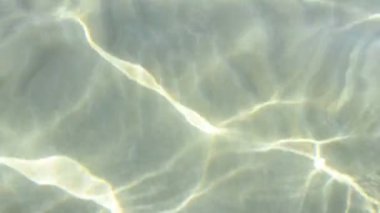 Deniz suyu dalgalanır. Güneş ışınları denizin yüzeyini dalgalandırıyor. 