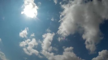 Mavi gökyüzünün bulutlarında yüksek güneş