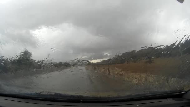 Viajando en coche bajo la lluvia con una cadena pesada — Vídeos de Stock