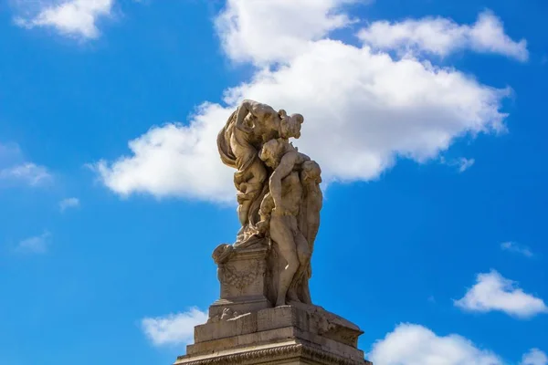 Woman kisses man statue in front of Altar of the Fatherland in Rome. Kissing sculpture in front of the Altare della Patria (Altar of the Fatherland) monument in Piazza Venezia (Venice Square). Rome, Italy.