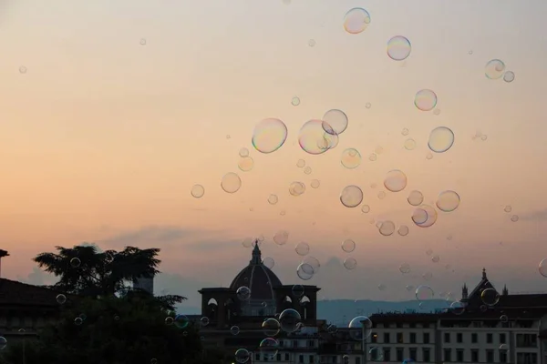 Soap bubbles soar in the air. Beautiful evening sunset in Florence. Soap bubbles evening sky. Florence, Italy.