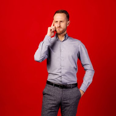 kırmızı arka plan üzerinde adam şüpheci görünümlü, dis bir grimace var