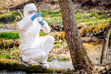 kadın bir test tüpünde su toplar. Ekoloji ve çevre 
