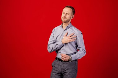 kırmızı arka plan üzerinde kalp ağrısı muzdarip adam. insanlar ve sağlık kavramı