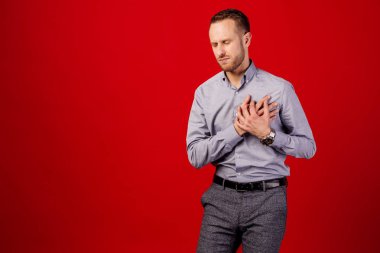 kırmızı arka plan üzerinde kalp ağrısı muzdarip adam. insanlar ve sağlık kavramı