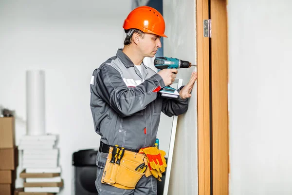 Worker with electrical screwdriver. Repair and building concept.