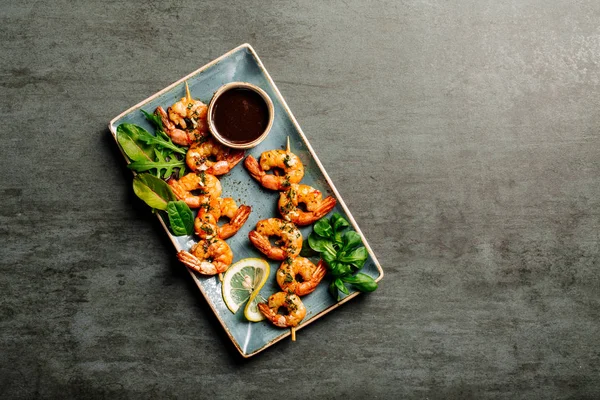 Delicious roasted shrimps on plate with lemon — Stock Photo, Image