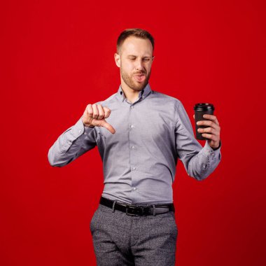 Kırmızı arka planda kahve fincanı olan kızgın yüzlü bir adam, Nega