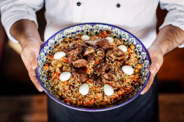 sebze, et ile özbek pilavı ulusal çanak tutan el 