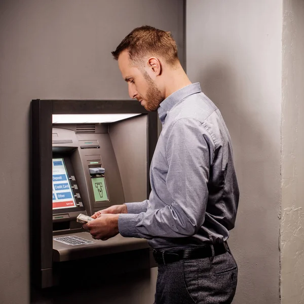 Hombre con ATM sobre fondo gris. personas y concepto de emoción . — Foto de Stock