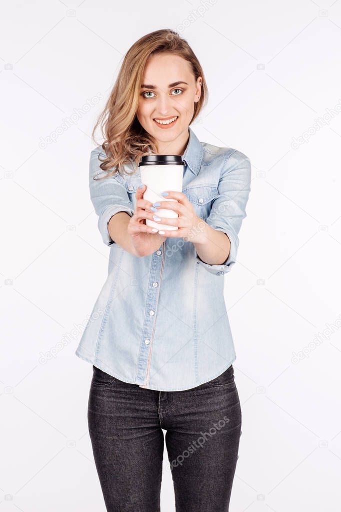 young woman with cup of coffee, smiling and looking into the cam