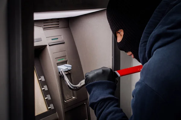 Злодій з палицею відкриває банкомат . — стокове фото
