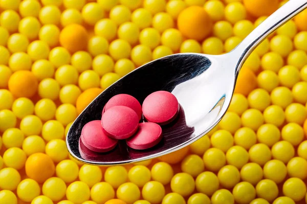 Pastillas rojas en cuchara, de cerca. Concepto médico . —  Fotos de Stock