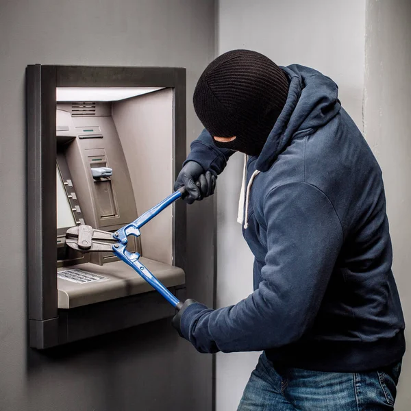 Ladrão com cortador de parafusos invade um multibanco. Conceito de lei e crime — Fotografia de Stock