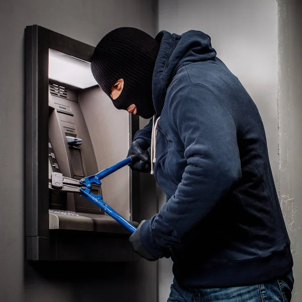 Злодій з різаком для болтів зламує банкомат. Закон і концепція злочину — стокове фото