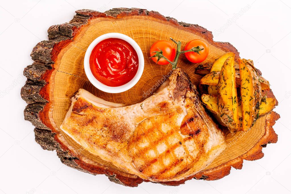 BBQ meat on wooden plate with sauce, potato and tomato. Menu con