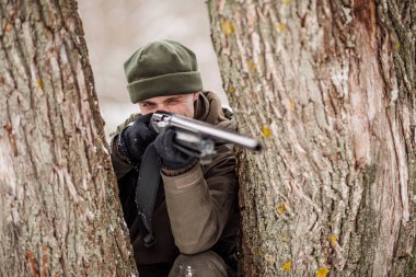 Kamuflaj, erkek avcısı silahlı bir tüfekle bir sno ayakta