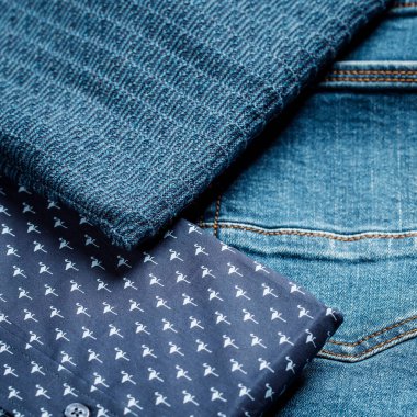 Bir sürü farklı erkek kıyafeti. Kazak, gömlek, kot pantolon. 