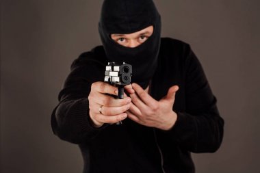 Hırsız ya da soyguncu tabanca ile nişan. siyah maskeli adam