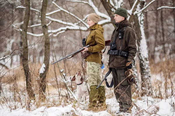 A puska egy havas téli erdőben két vadászok. — Stock Fotó