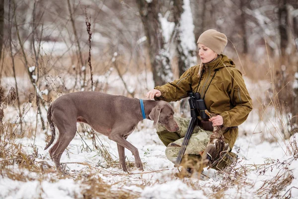 Kvinnliga jägare i kamouflage, beväpnad med ett gevär, stående i en s — Stockfoto