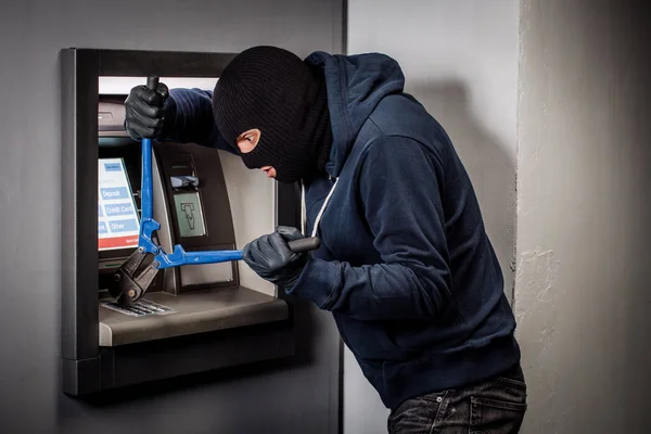 Ladrão com cortador de parafusos invade um multibanco. Conceito de lei e crime — Fotografia de Stock