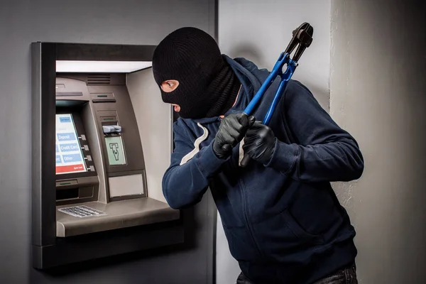 Ladrão com cortador de parafusos invade um multibanco. Conceito de lei e crime — Fotografia de Stock