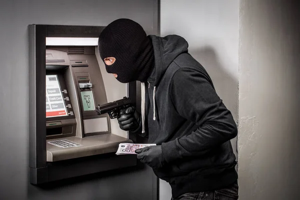 Ladrão com uma arma rouba um ATM — Fotografia de Stock