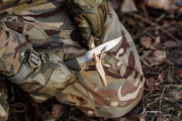 Soldat schnitt mit Messer einen Holzstock. — Stockfoto