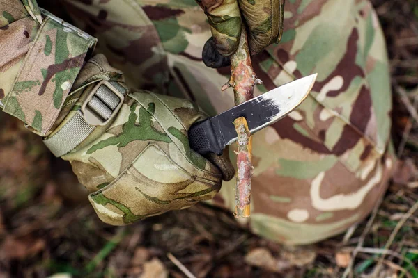 ナイフを持った兵士が木の棒を切った. — ストック写真