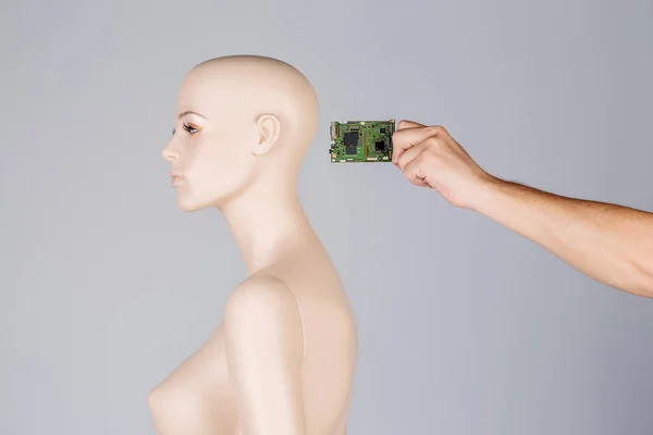 Tangan memasukkan chip kontrol ke dalam kepala robot. merampok perbaikan — Stok Foto