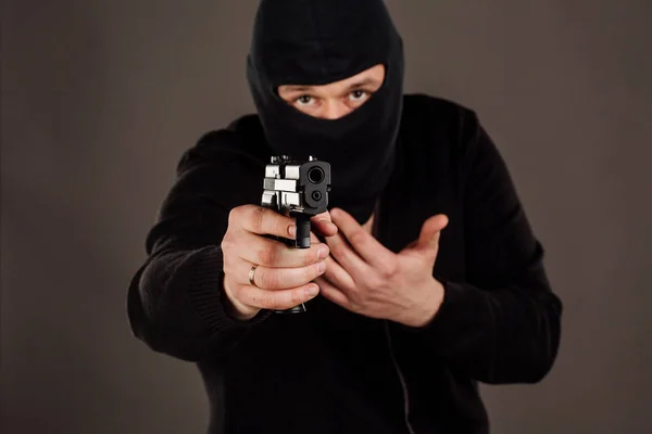 Ladrón o ladrón apuntando con pistola. hombre con máscara negra — Foto de Stock