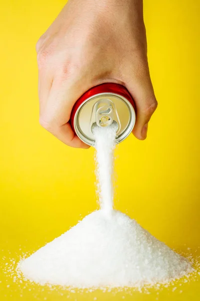 Hand holding soda can with sugar. Diet and sweet addiction conce
