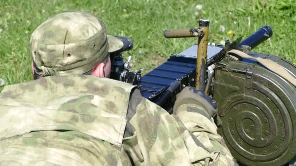 Ein Militär, das aus einem Maschinengewehr in Schutzform zielt — Stockvideo