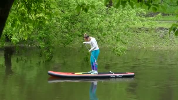 Flicka kanot på dammen på sommaren — Stockvideo