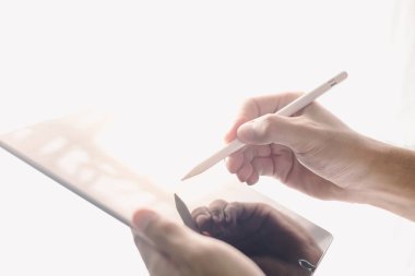 Stylus ve dijital tabletle çalışmanın yakın plan görüntüsü. Bulanık arka plan ışığı, yatay yakınlaştırma