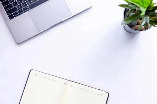 laptop and notebook on white background