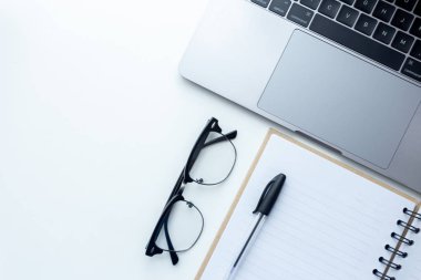 Üstten görünüm çalışma alanı, arka plan üzerinde kahve Kupası ve ofis donanımları ile beyaz masa üstünde laptop